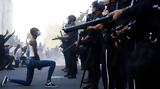 Η φωτογραφία με την μαύρη διαδηλώτρια που γονάτισε μπροστά στο «τείχος» των αστυνομικών,συγκλόνισε το διαδίκτυο